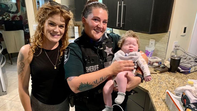 Lee County deputy with baby whose life she saved and her mother. 