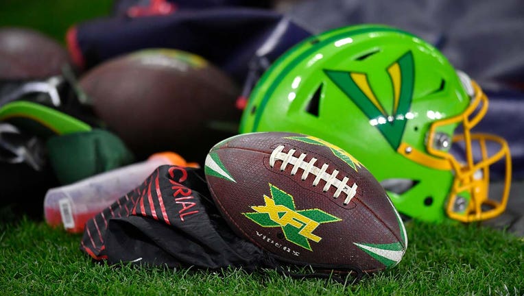 Photo: Image of XFL football resting on football field, along with the bright green Vipers helmet