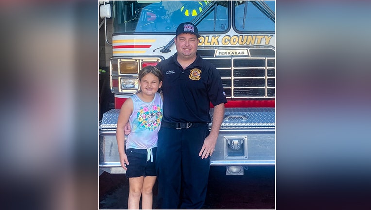 Paisley posing with her EMT father at fire house. 