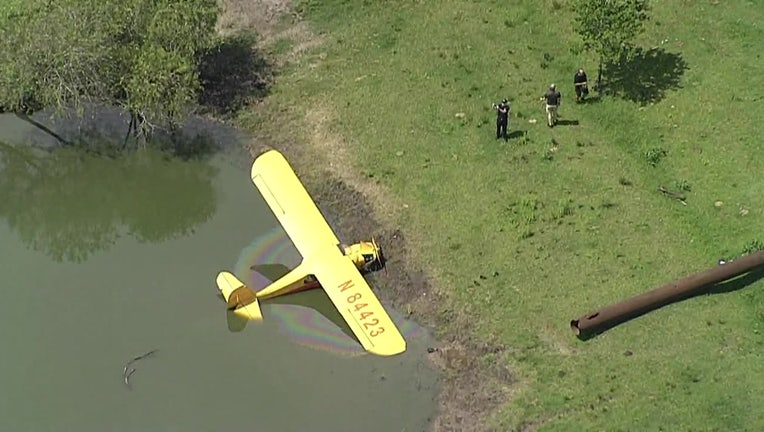 Photo: Small yellow plane resting in pond