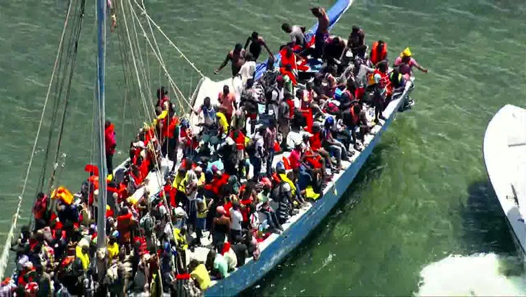 Photo: Large number of migrants sit aboard a grounded sailboat off the coast of South Florida.