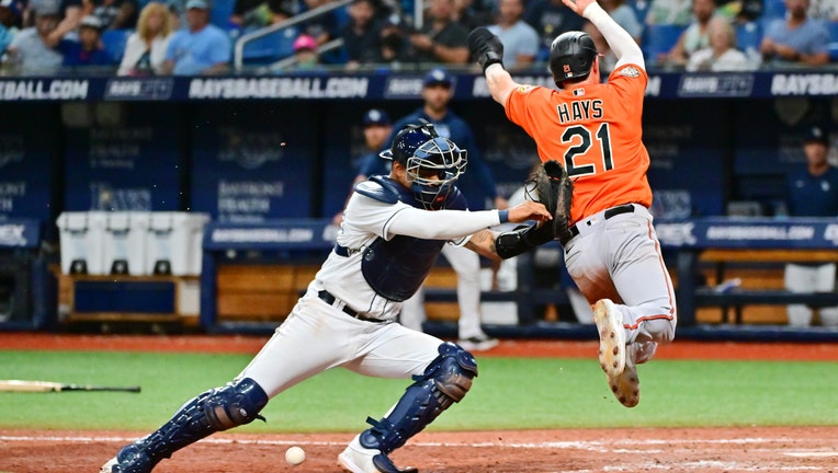 Christian Bethancourt #14 of the Tampa Bay Rays drops the ball before making the tag on Austin Hays #21 of the Baltimore Orioles in the tenth inning at Tropicana Field on July 16, 2022 in St Petersburg, Florida. 