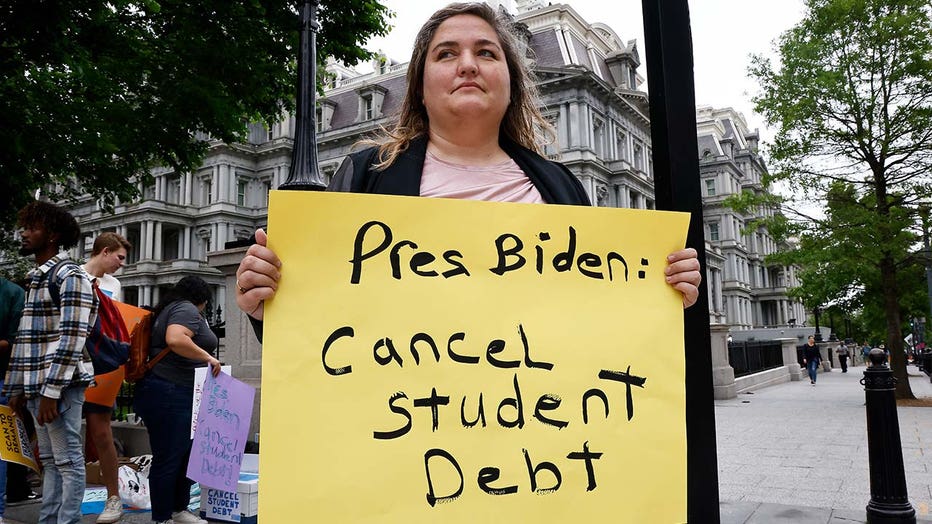 Photo: Student holds yellow sign that reads, 'Pres Biden: Cancel student debt