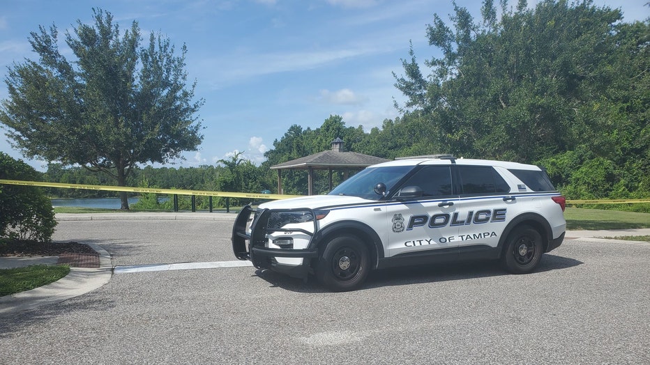 Police vehicle and crime scene tape around dock in Grand Hampton neighborhood where a man's body was found.
