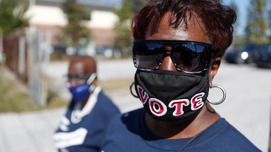 Easter Curry wears a face covering reading VOTE while campaigning for a local candidate near the Seminole Heights Public Library polling precinct on November 3, 2020 in Tampa