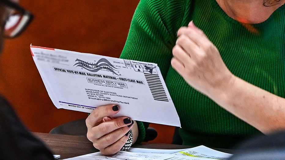  Electoral workers are seen during the vote-by-mail ballot scanning process at the Miami-Dade County Election Department i