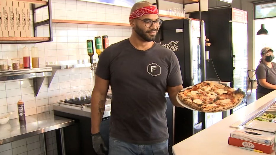 Photo: Employee holds Fabrica Pizza