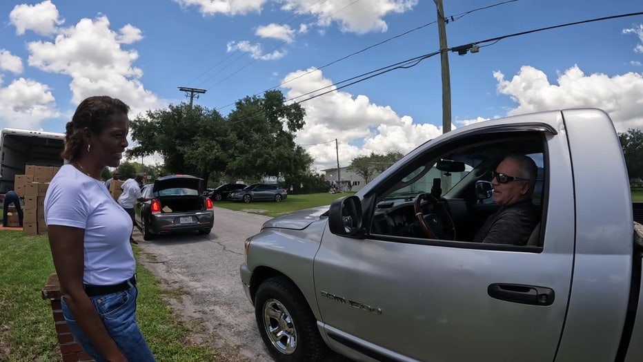 Volunteers ahdn out food in car line for Bags of Blessings