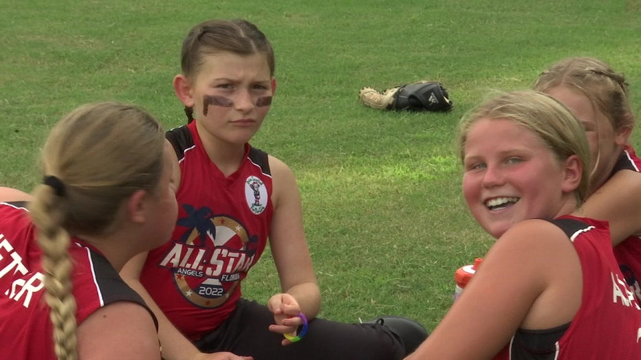 Four girls from West Pasco Girls' Softball team talking to each other. 