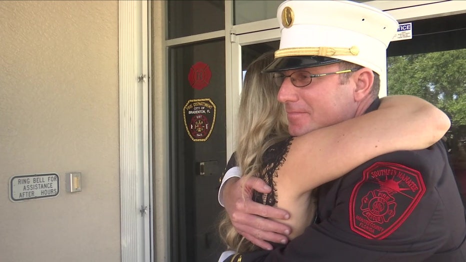 Brianne Baker hugs firefighter who saved her life with kidney donation. 