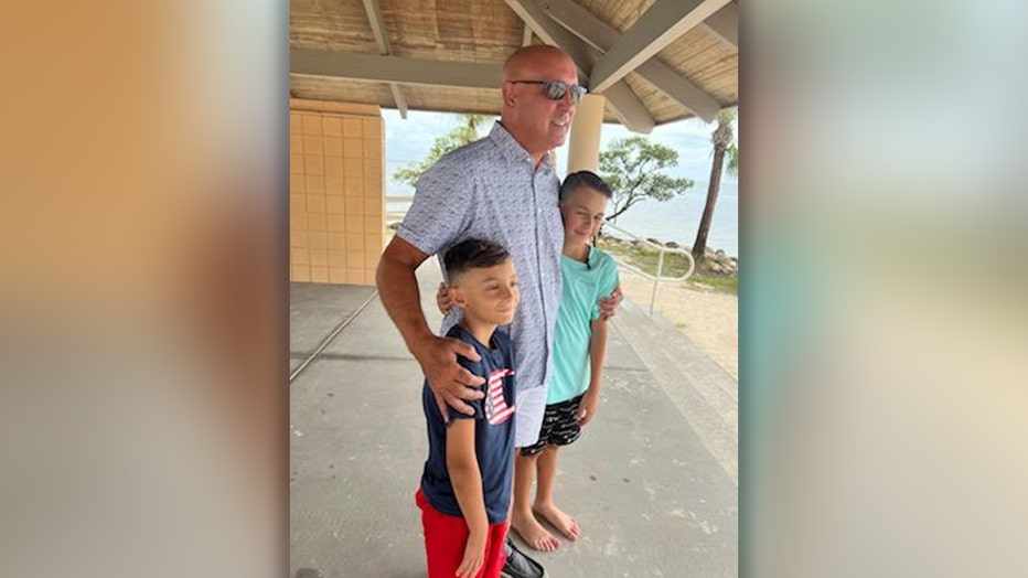 Photo: Pinellas Deputy Anthony LaCorte takes a photo with the two children he saved from a rip current off Anclote Island.