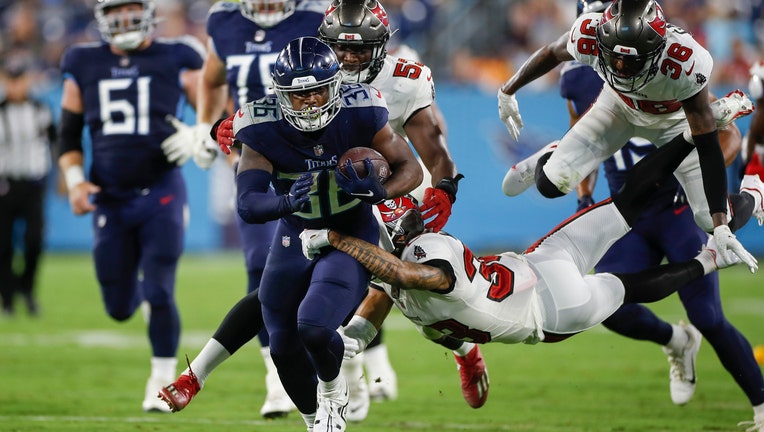 ulius Chestnut #36 of the Tennessee Titans runs with the ball while being tackled by a Tampa Bay Buccaneer defender during fourth quarter of the pre-season game at Nissan Stadium on August 20, 2022 in Nashville, Tennessee. 