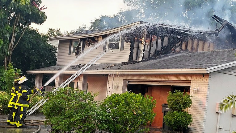 Photo: Firefighters using hoses to douse flames