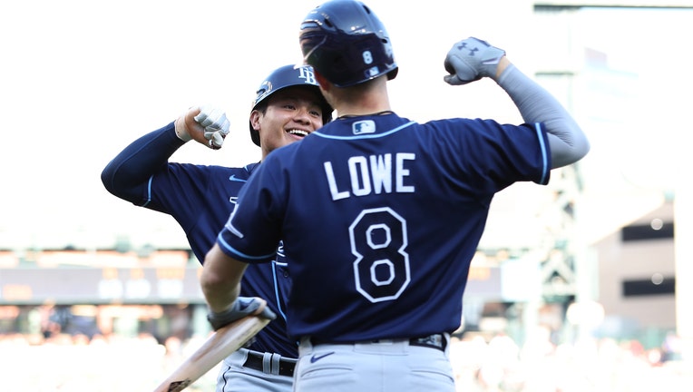 Yu Chang #9 of the Tampa Bay Rays celebrates scoring a run in the second inning with Brandon Lowe #8 while playing the Detroit Tigers at Comerica Park on August 06, 2022 in Detroit, Michigan.