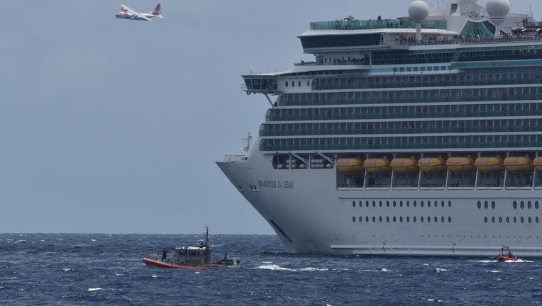 Coast Guard boat in the water and plane in the air next to cruise ship. 