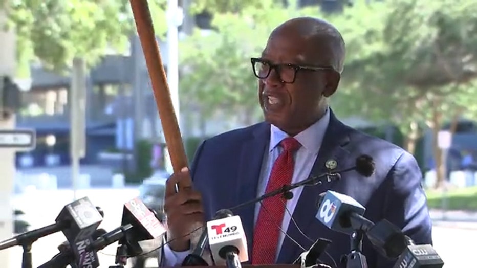 Photo: Mayor Welch holds axe handle -- built by his uncle -- before his June announcement of scrapping the initial RFP proposals and starting over.
