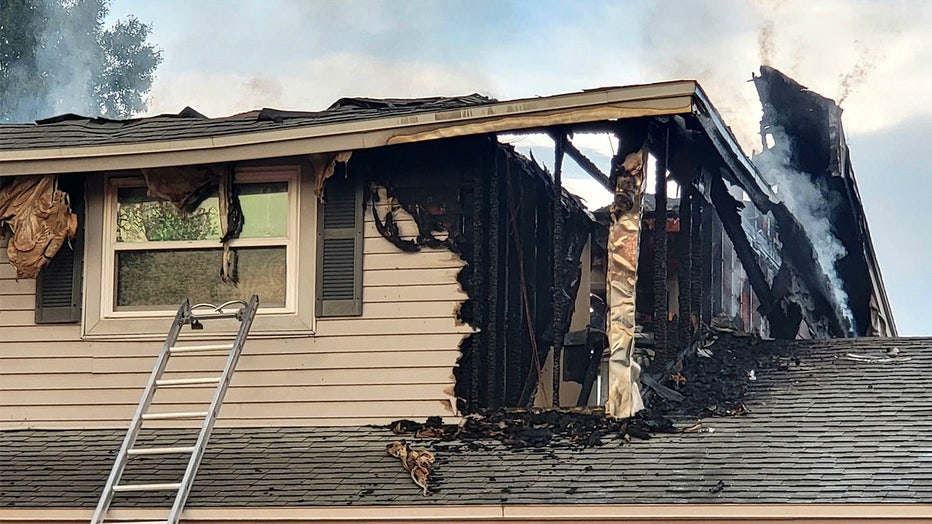 Photo: Second-story roof is scorched from lightning strike and fire, exposing inside of home