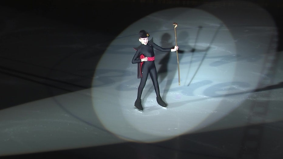 Figure skater on ice with cane.