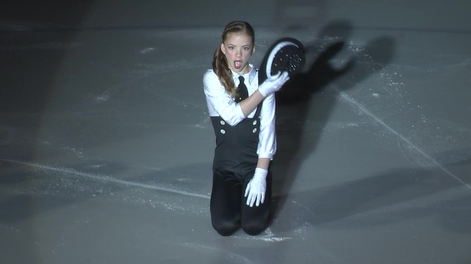 Female figure skater on ice with hat. 