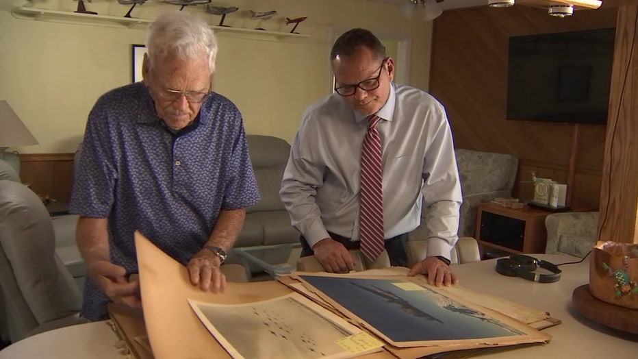 Kenneth Beckman looks over old photos with FOX 13's Lloyd Sowers. 