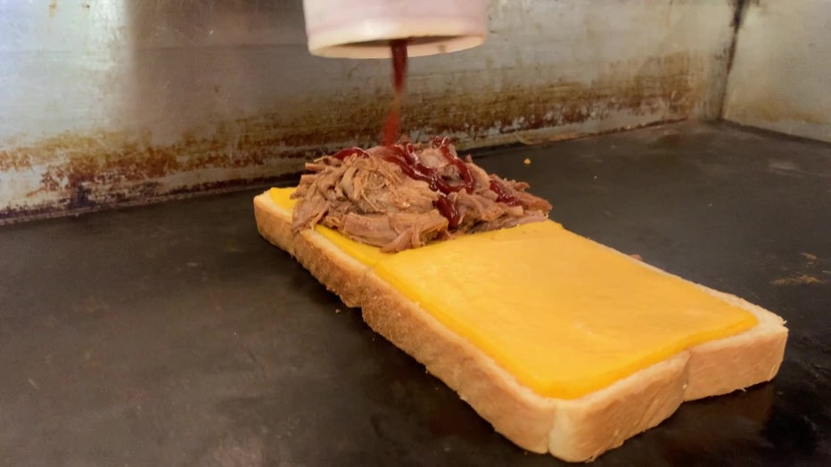 Melt Machine brisket melt with cheese on the grill.