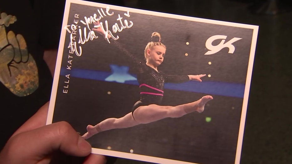 Gymnast Ella Kate Parker autographs photos at U.S. National Gymnastics Championships.