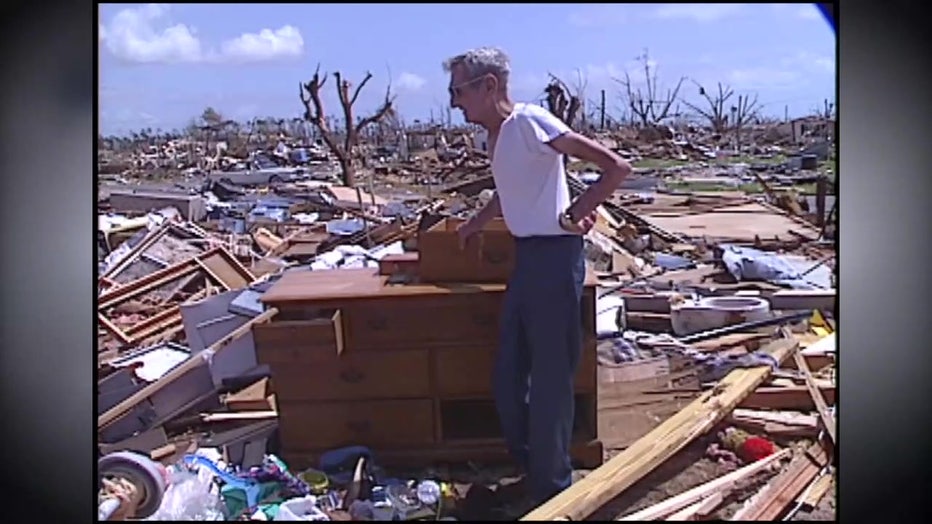 A man stands in the middle of rubble left by Hurricane Andrew. 