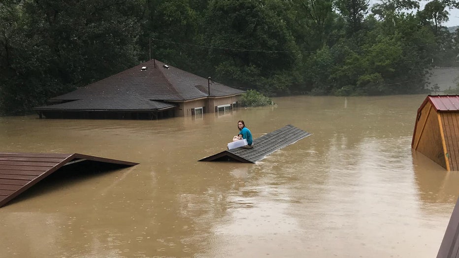 Photo: Chloe Adams and her dog sit on her neighbor's roof awaiting rescue from Kentucky's historic flash flooding.