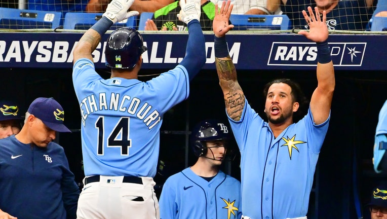 Christian Bethancourt #14 of the Tampa Bay Rays celebrates with David Peralta #6 after hitting a home run in the second inning `atex at Tropicana Field on September 18, 2022 in St Petersburg, Florida.