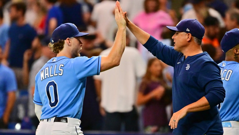 Manager Kevin Cash #16 of the Tampa Bay Rays high fives Taylor Walls #0 after defeating the Texas Rangers 5-1 at Tropicana Field on September 17, 2022 in St Petersburg, Florida.