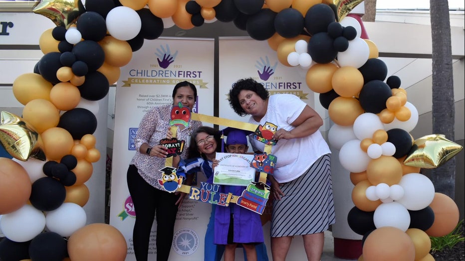 Child poses with family at Headstart graduation