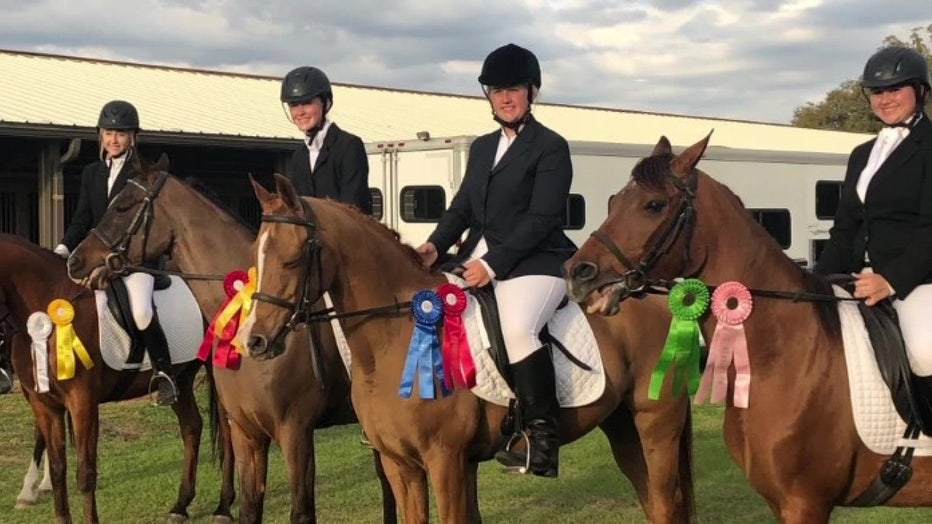 Students from Summerlin Academy sit atop horses.