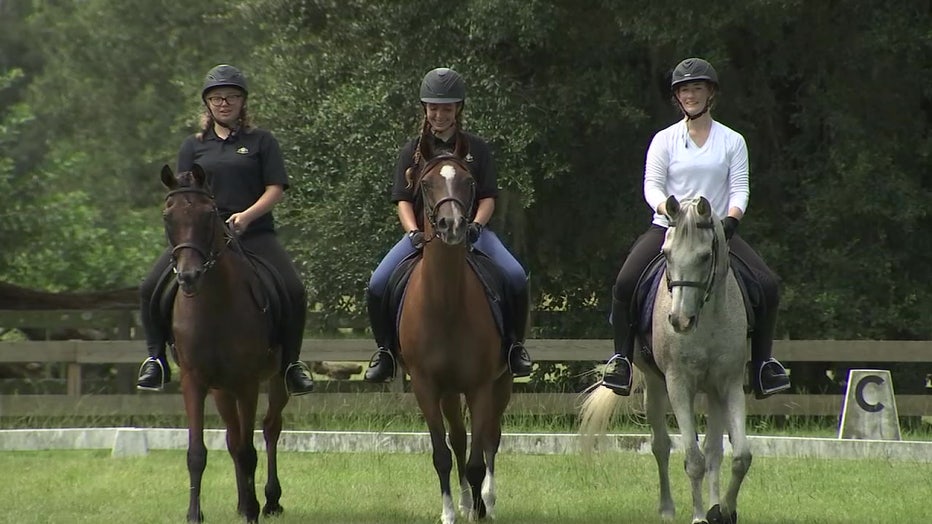 Students from Summerlin Academy sit atop horses.