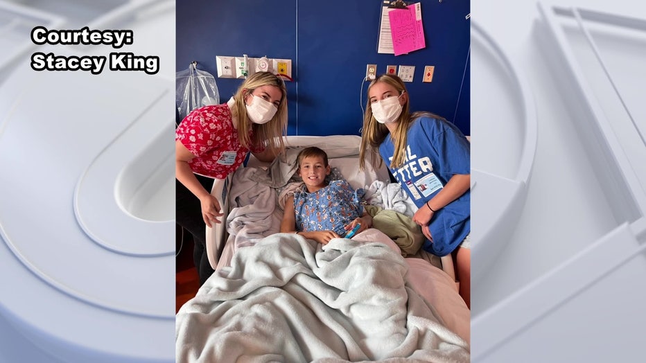 Colton King sits in a hosptial bed with his mother and sister.