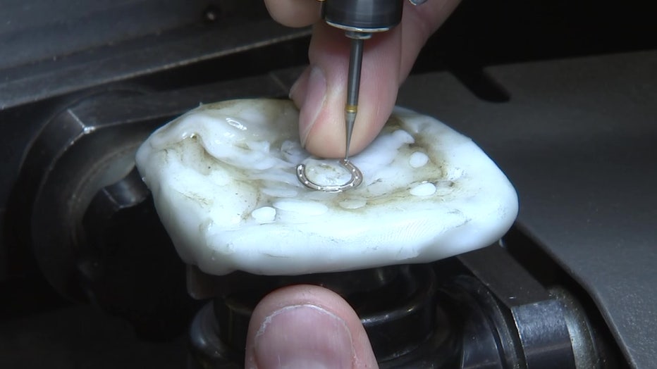 Close-up of diamonds being placed into white gold. 