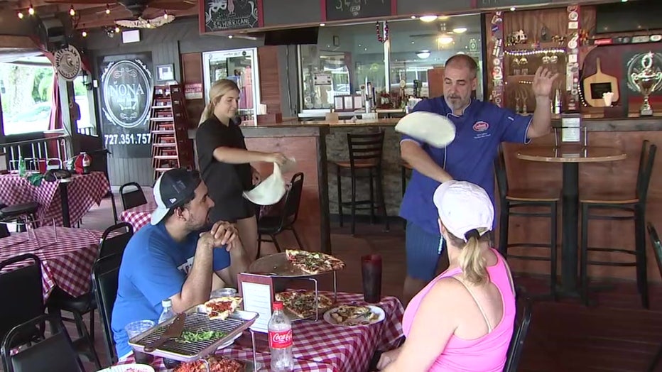 Jamie Culliton performs pizza acrobatics inside the Nona Slice House. 