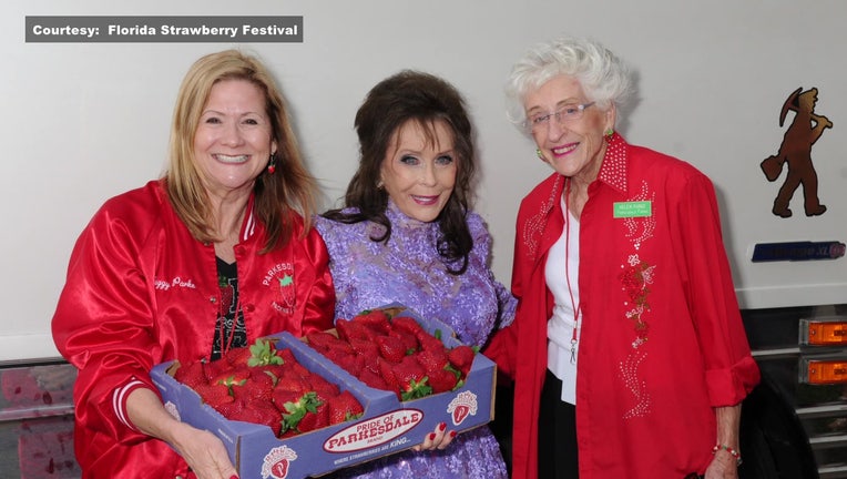 Loretta Lynn poses for a photo with two women at the Strawberry Festival. 