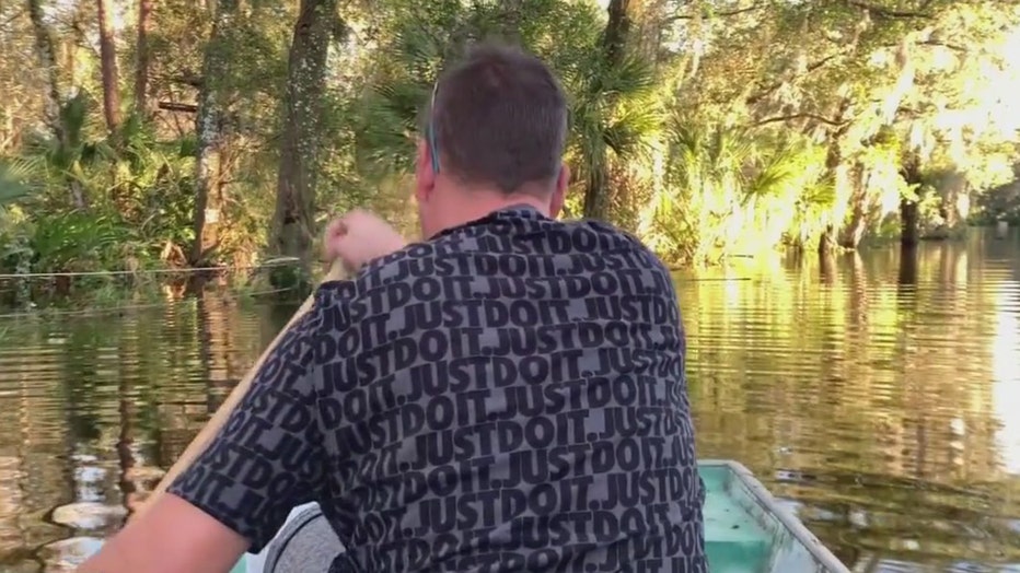 Residents near Alafia River use boats to travel flooded roadways