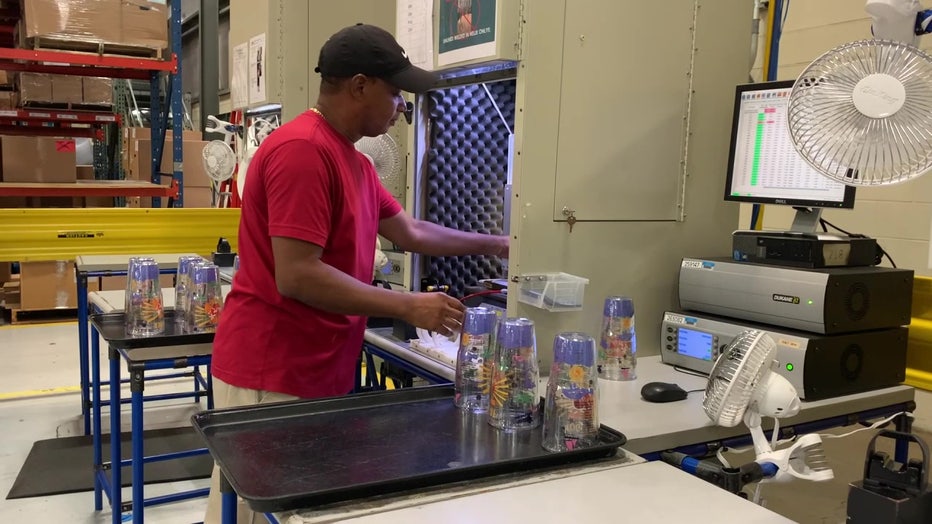 An employee makes a Tervis tumbler.
