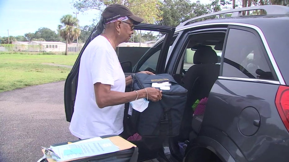 Meals on Wheels volunteer loads meal into the car. 