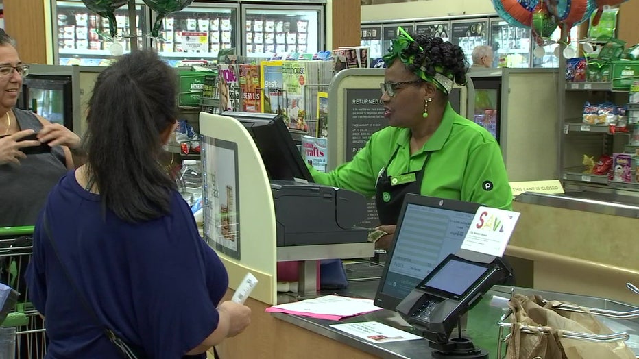 Customers will wait in a long line to have Gloria Withlock Blue as a cashier. 