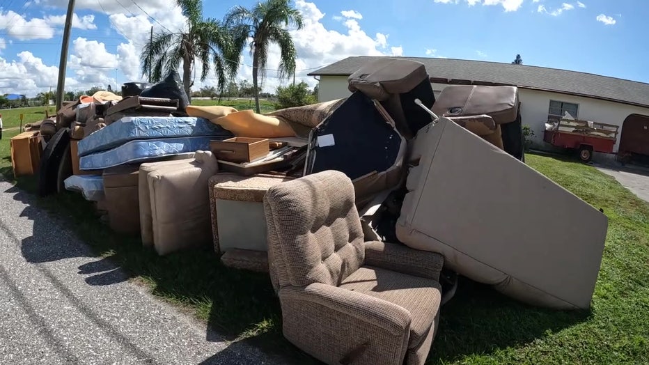 Furniture damaged by flooding from Hurricane Ian sits out by the curb in an Englewood neighborhood.