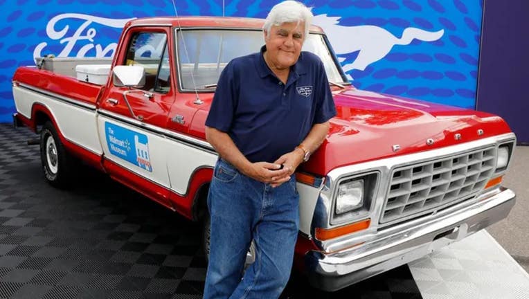 Comedian Jay Leno poses in front of a 1979 Ford F-150 pickup.