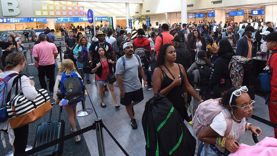 Travelers make their way through a TSA screening line at Orlando International Airport.