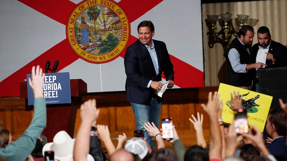Republican Florida Gov. Ron DeSantis tosses hats before giving a campaign speech at a rally for Florida Republicans at the Cheyenne Saloon on November 7, 2022 in Orlando, Florida