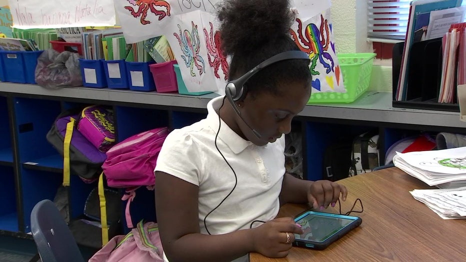 A child is learning to read by singing. 