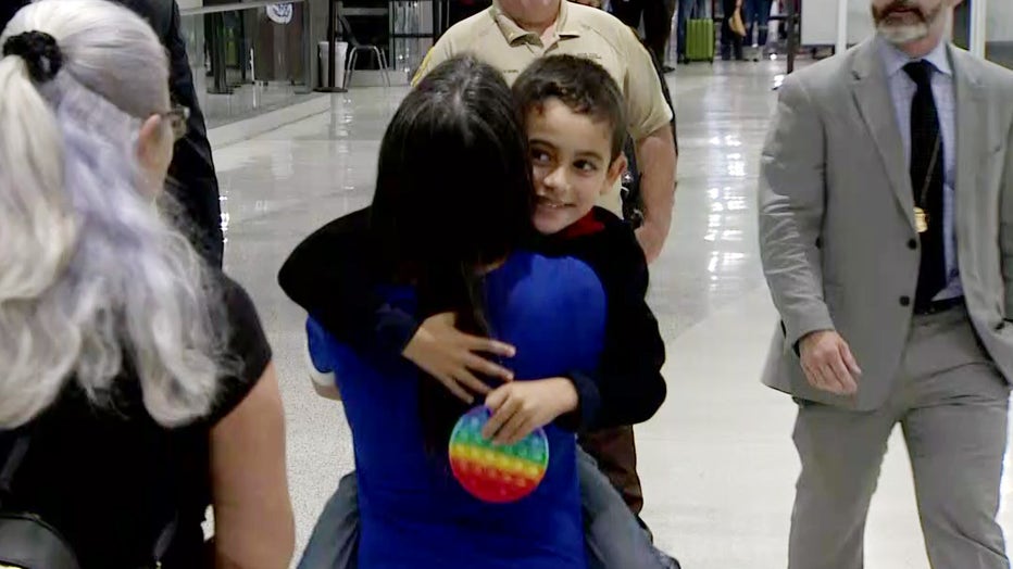 6-year-old Jorge "JoJo" Morales smiles as he hugs his mother.