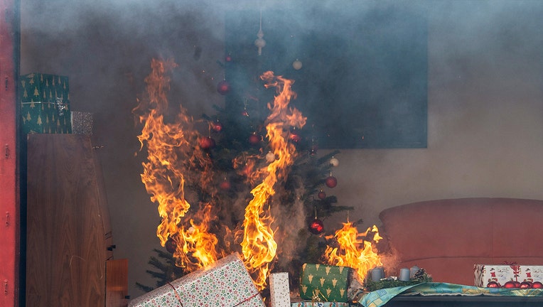 A burning Christmas tree and gifts stand in a replica living room during a demonstration. The fire department has informed about the dangers at Christmas and New Year's Eve.