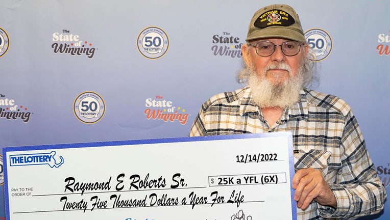 Raymond Roberts Sr. holds up a giant $25,000 for life check after winning the lottery prize six times by playing the same numbers for a single drawing.