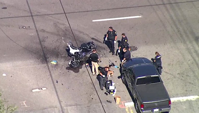 Investigators gather around the damaged motorcycle.